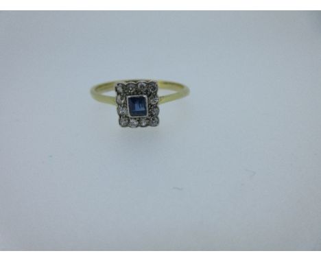 An early 20th century sapphire and diamond cluster ring, the central rectangular facetted sapphire surrounded by twelve pavé 