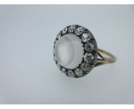 A moonstone and diamond cluster ring, the central round high domed cabochon moonstone surrounded by a border of fifteen pavé 