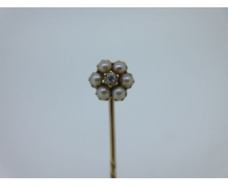 A pearl and diamond stick pin, designed as a flowerhead, the central crimp collet set old cut diamond surrounded by six half 