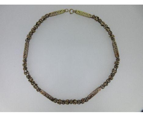 A fancy link necklace, comprising alternating short lengths of textured byzantine link chain and hollow pierced box sections,