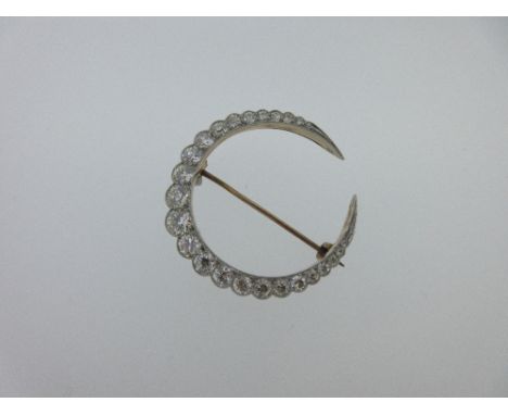A late 19th century diamond closed crescent brooch, set with a graduated curve of round old brilliant cut diamonds tapering t
