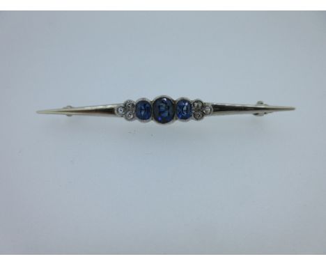 A sapphire and diamond nine stone bar brooch, the central section set with three graduating rub over and millegrain edged ova