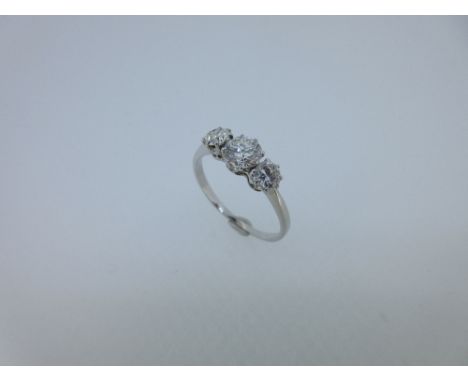 A three stone diamond ring, the graduated round old brilliant cut diamonds claw set with a coronet gallery, to a plain tapere