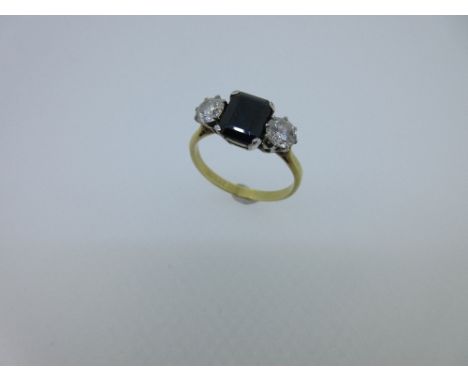 A sapphire and diamond three stone ring, the octagonal cut sapphire between two round brilliant cut diamonds, all collet set,