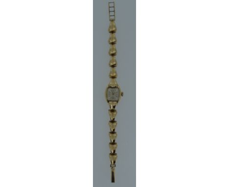 Imaco &amp; Rolex - A lady's 9ct gold wristwatch, circa 1956, the signed silvered square dial with gold coloured batons and h