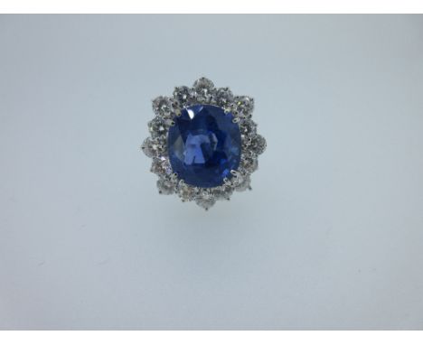 An important sapphire and diamond cluster ring, the rectangular cushion shaped mixed cut sapphire weighing 7.16ct, double cla