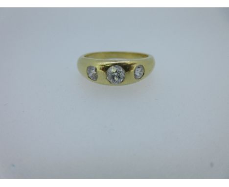 A three stone diamond ring, the three graduating old cut diamonds in spaced rub over gypsy settings total estimated weight of