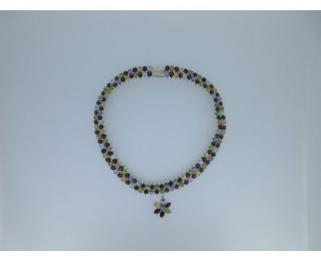 A 'tutti-frutti' gem set collar, with two concentric rows of articulated claw set oval facetted hardstones including garnet, 