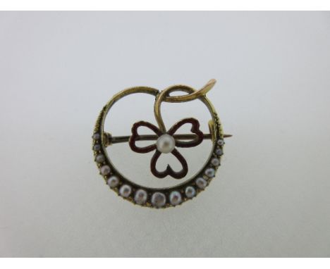 A seed pearl and enamel crescent and shamrock brooch, of open form, the three shamrock leaflets delineated in red enamel with