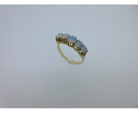 A five stone opal half hoop style ring, the five graduating round cabochon opals claw set to a solid gallery, the plain shoul