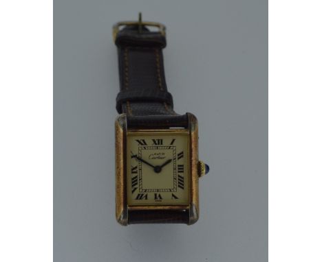 Cartier - A vermeil 'Les must de Cartier' 'Tank' wristwatch, circa 1990, the signed rectangular parchment coloured dial with 