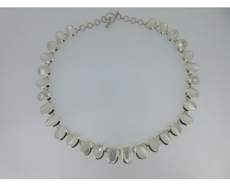 A modern silver necklace set with moonstones, the necklace of 29 individually rub over set graduating oval cabochon moonstone