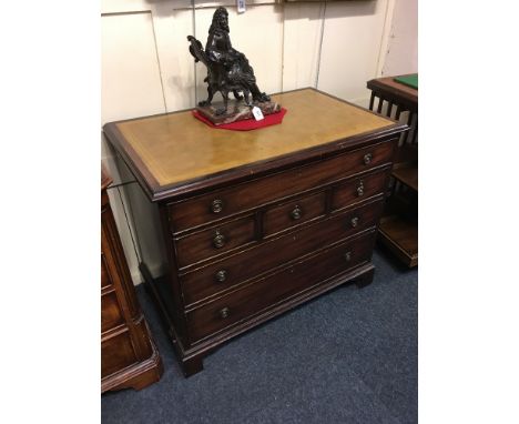 A George III style mahogany writing chest with yellow tooled leather top, frieze drawer above smaller drawers and two long dr