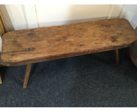 A rustic oak bench/ long stool with four sloping legs (some woodworm a/f), 86cm