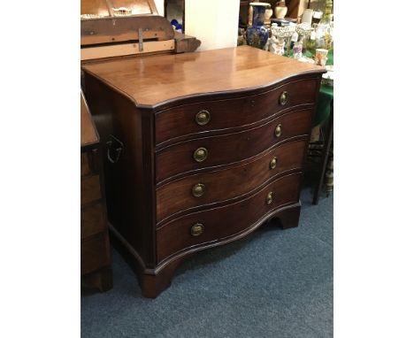 A George III mahogany secretaire chest, with serpentine shaped top above a secretaire drawer enclosing a fitted interior and 