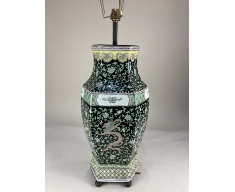 A Chinese porcelain vase table lamp, depicting dragons within flowering foliage, on black ground, 62cm high