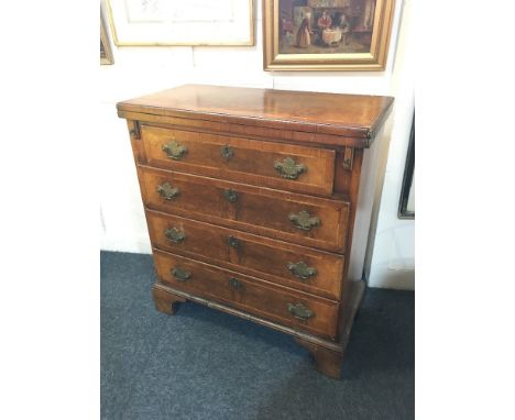 A reproduction walnut batchelor's chest of four drawers with rectangular crossbanded and herringbone inlaid fold over top, on