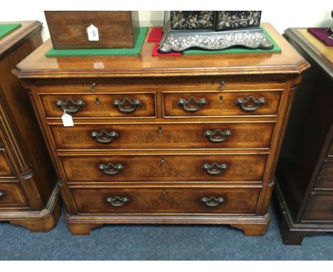 A George III style walnut and feather banded chest of two short over three long drawers with brushing slide on bracket base, 