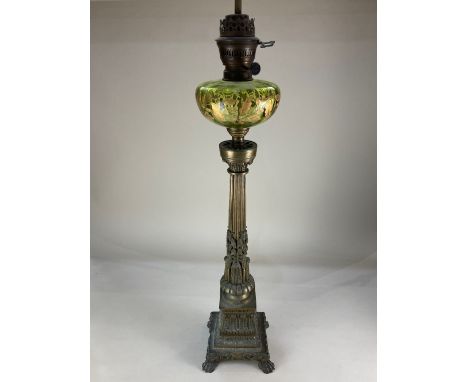 A large brass Corinthian column oil lamp, converted into an electric table lamp, the green glass font with gilt oak leaf desi
