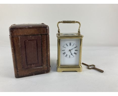 An Edwardian brass and bevelled glass cased carriage clock, the white enamel dial with Roman numerals, the French movement ha