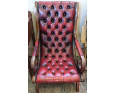 A maroon leather button back armchair