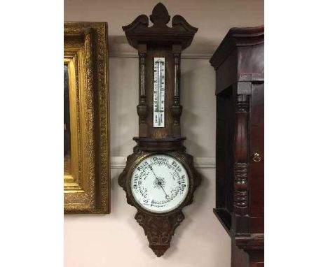 A late Victorian carved oak aneroid barometer