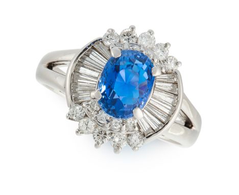 A SAPPHIRE AND DIAMOND CLUSTER RING in platinum, set with an oval cut sapphire of 1.93 carats in a border of round and baguet
