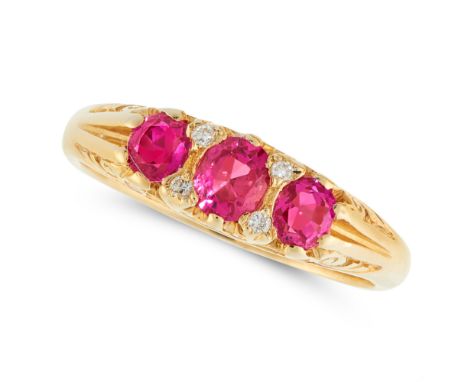 A RUBY AND DIAMOND DRESS RING in 18ct yellow gold, set with a trio of graduated cushion cut rubies punctuated by pairs of rou