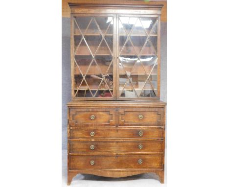 A late Georgian mahogany library bookcase with upper glazed section above fitted central secretaire drawer above three furthe