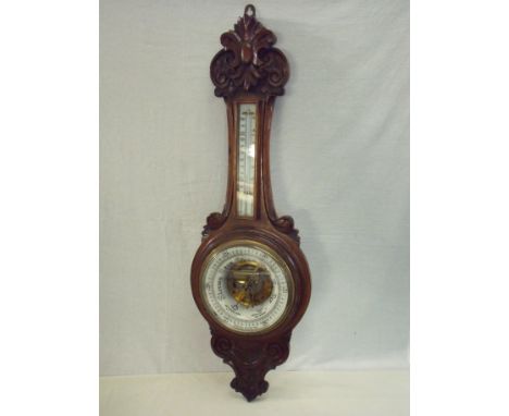 Wall mounted carved oak cased aneroid wall barometer with sunken white enamel centre 
