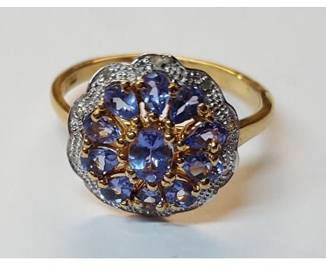 Silver gilt daisy style dress ring set with central tanzanite stone and flanked by ten tear drop topaz stones (size V)