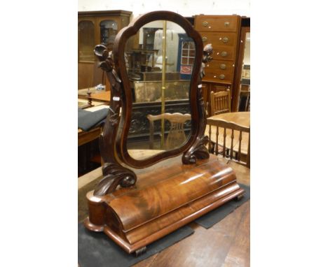 A Victorian mahogany toilet mirror, the shaped plate on foliate and floral carved supports to the lidded compartment base on 