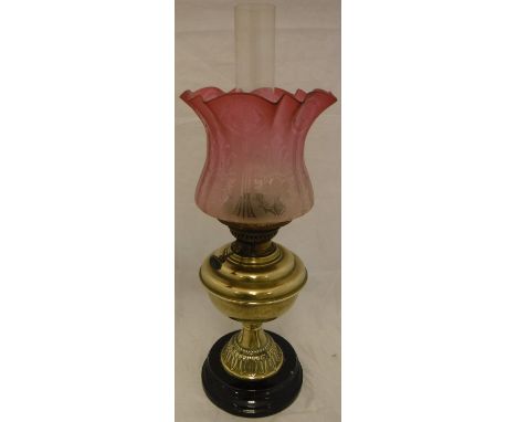 A Victorian brass oil lamp with etched cranberry glass shade and clear glass funnel CONDITION REPORTS Numerous light surface 