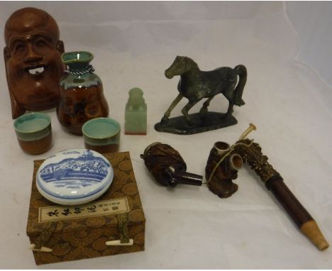 A boxed Saki set, a Buddha wall mask, a carved stone figure of a horse, a pipe, a Chinese seal, a Chinese porcelain lidded bo