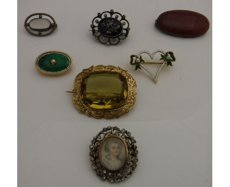 Seven assorted brooches to include one set with puce coloured Ruskin disc, stamped "Ruskin" verso, together with a yellow met