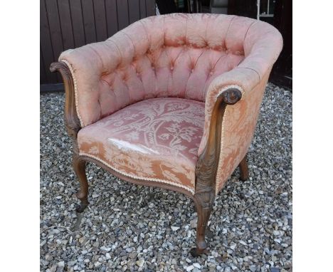 A circa 1900 button upholstered tub chair withcarved mahogany show frame in Louis XV taste raised on brass caps to china cast