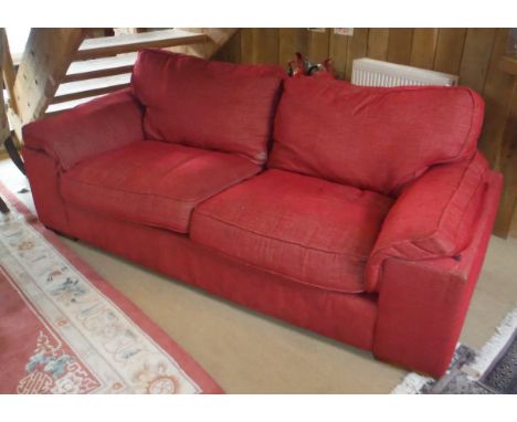 A modern red upholstered three seat sofa