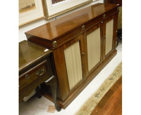 A late Regency rosewood side cabinet, the plain top over a frieze decorated with brass rams head medallions over three fabric