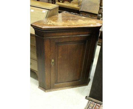 An oak corner cupboard, together with an Edwardian mahogany and inlaid occasional table, the oval top on square tapering outs