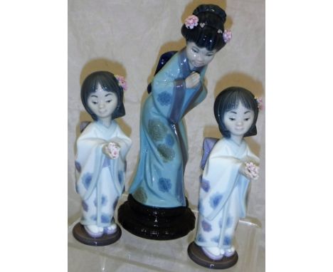 A Lladro figurine of "A geisha", together with two Lladro figurines of "Girls with lotus blossom in hands", No'd. 6151 to bas