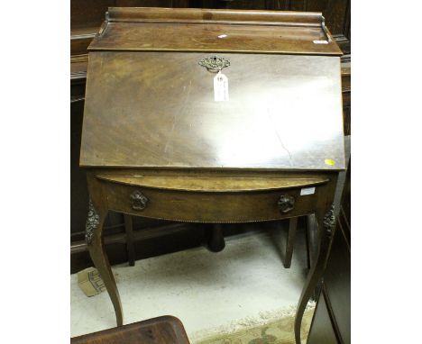 An early 20th Century mahogany bureau de dame, the fall front opening to reveal a fitted interior above a bow front drawer ra