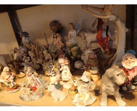 Shelf of resin fairy figurines etc