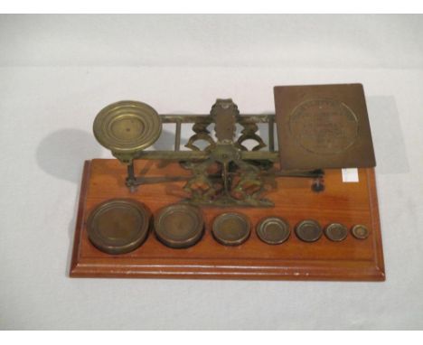 A glazed mahogany balance scales with weights  