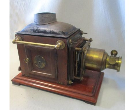 A magic lantern projector, boxed with heavy carrying handles, with lacquered brass mounts and mahogany body, the lantern 50cm