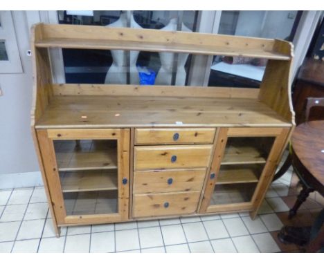 A MODERN PINE SIDE CABINET WITH UPPER SHELF, and four drawers flanked by glazed cupboards below 