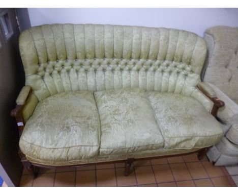 A THREE SEATER SOFA, with carved mahogany frame and green upholstery 