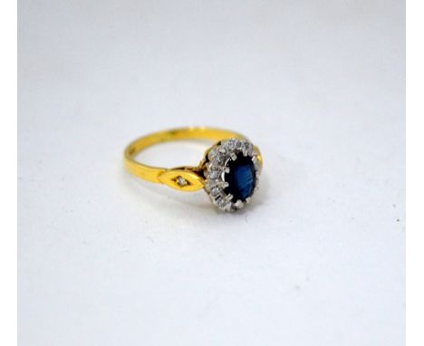 AN 18CT GOLD SAPPHIRE AND DIAMOND RING, with central oval sapphire within a surround and diamonds to the diamond tapered band