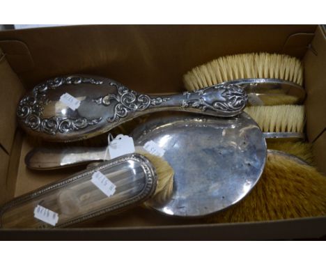 A FIVE PIECE SILVER MOUNTED DRESSING TABLE SET, comprising four brushes and a mirror, Birmingham 1923/4, together with emboss