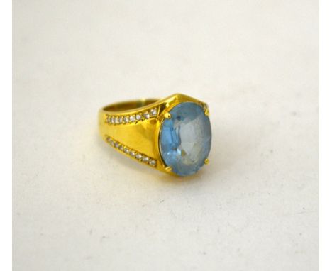 A DIAMOND AND TOPAZ DRESS RING, with central oval shape topaz to the tapered diamond shank, stamped 18K