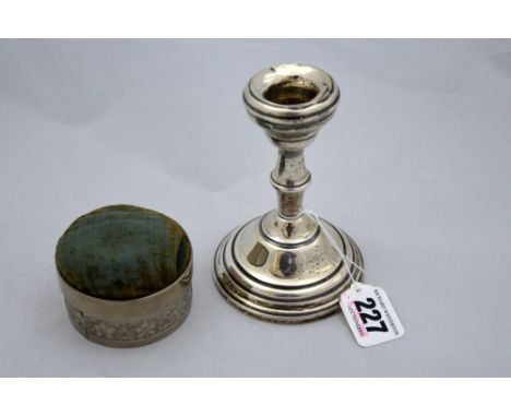 A SILVER CANDLESTICK, together with white metal mounted pin cushion (2)